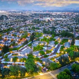 Welcome home aerial view of a community with streets and buildings